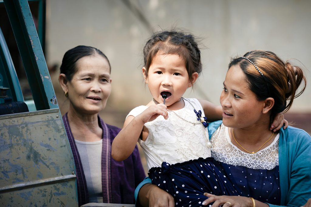 Khammouane Province, Laos, 2015 Village life in Laos: A mother and daughter spend time together while a friend watches on. Photo taken during a Community Based Disaster Risk Reduction simulation. The exercises and drills focus on disaster preparedness and response at village level, ensuring communities are equipped with skills to activate emergency plans and save lives.