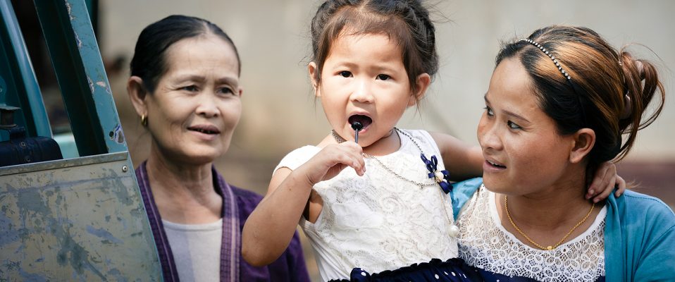 Khammouane Province, Laos, 2015 Village life in Laos: A mother and daughter spend time together while a friend watches on. Photo taken during a Community Based Disaster Risk Reduction simulation. The exercises and drills focus on disaster preparedness and response at village level, ensuring communities are equipped with skills to activate emergency plans and save lives.