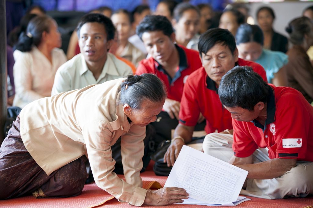 Khammouane Province, Laos, 2015 Planning checks. Members of Village Disaster Protection Units go over the schedule for a Community Based Disaster Risk Reduction simulation. The exercises and drills focus on disaster preparedness and response at village level, ensuring communities are equipped with skills to activate emergency plans and save lives. Through the simulation project Lao Red Cross and partner French Red Cross, with support from the European Union, are improving safety for vulnerable communities.