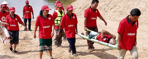 Khammouane Province, Laos, 2015 Transporting the patient. Participants practice transporting a patient during a Community Based Disaster Risk Reduction simulation. The exercises and drills focus on disaster preparedness and response at village level, ensuring communities are equipped with skills to activate emergency plans and save lives. Through the simulation project Lao Red Cross and partner French Red Cross, with support from the European Union, are improving safety for vulnerable communities.