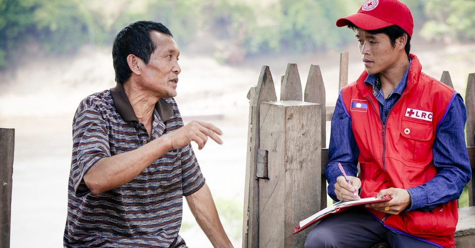 Khammouane Province, Laos, 2015 Lao Red Cross staff interview father and farmer Hong, 47, about his experience with floods during a Community Based Disaster Risk Reduction simulation. The exercises and drills focus on disaster preparedness and response at village level, ensuring communities are equipped with skills to activate emergency plans and save lives. Through the simulation project Lao Red Cross and partner French Red Cross, with support from the European Union, are improving safety for vulnerable communities.