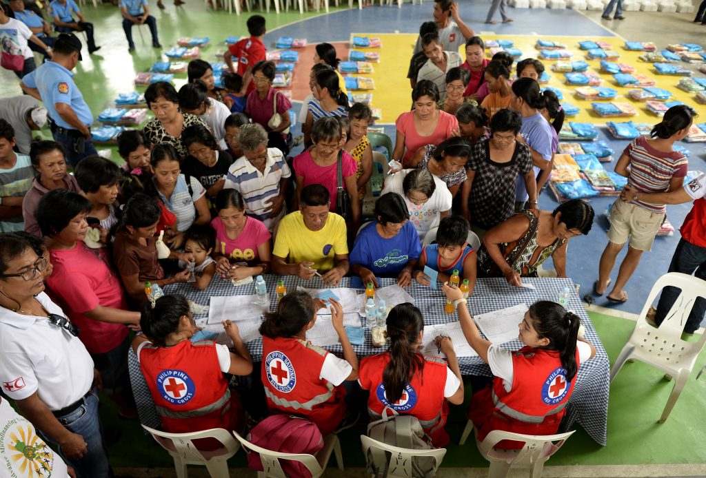 Red Cross volunteers man the table for registration of residents affected by flood caused by Typhoon Koppu that will receive food items and sleeping mats at Barangay Delfin, Albano, Isabela, north of Manila on October 20, 2015.