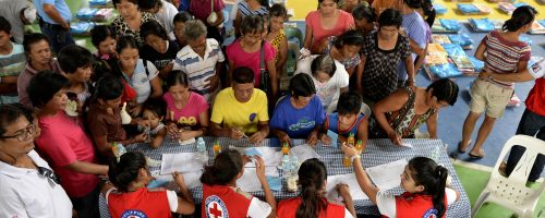 Red Cross volunteers man the table for registration of residents affected by flood caused by Typhoon Koppu that will receive food items and sleeping mats at Barangay Delfin, Albano, Isabela, north of Manila on October 20, 2015.