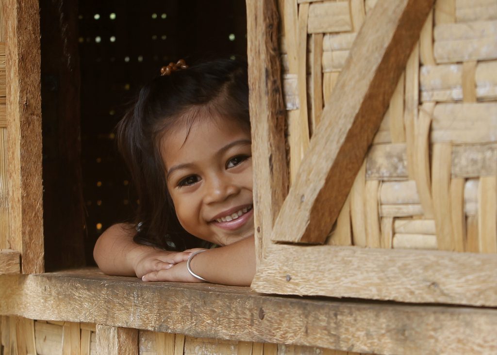 Alh Rose Pulinio, whose family is one of the beneficiary of full house, smiles as she looks out from the window of their home at Barangay Macopa in Monkayo, Compostela Valley southern Philippines November 30, 2013. One year after Typhoon Bopha locally known as Pablo destroyed houses and infrastructures and displaced thousands of residents, the IFRC and the Philippine Red Cross continue to help survivors recover with income generation projects and building of decent shelters. Photo by: Cheryl Gagalac